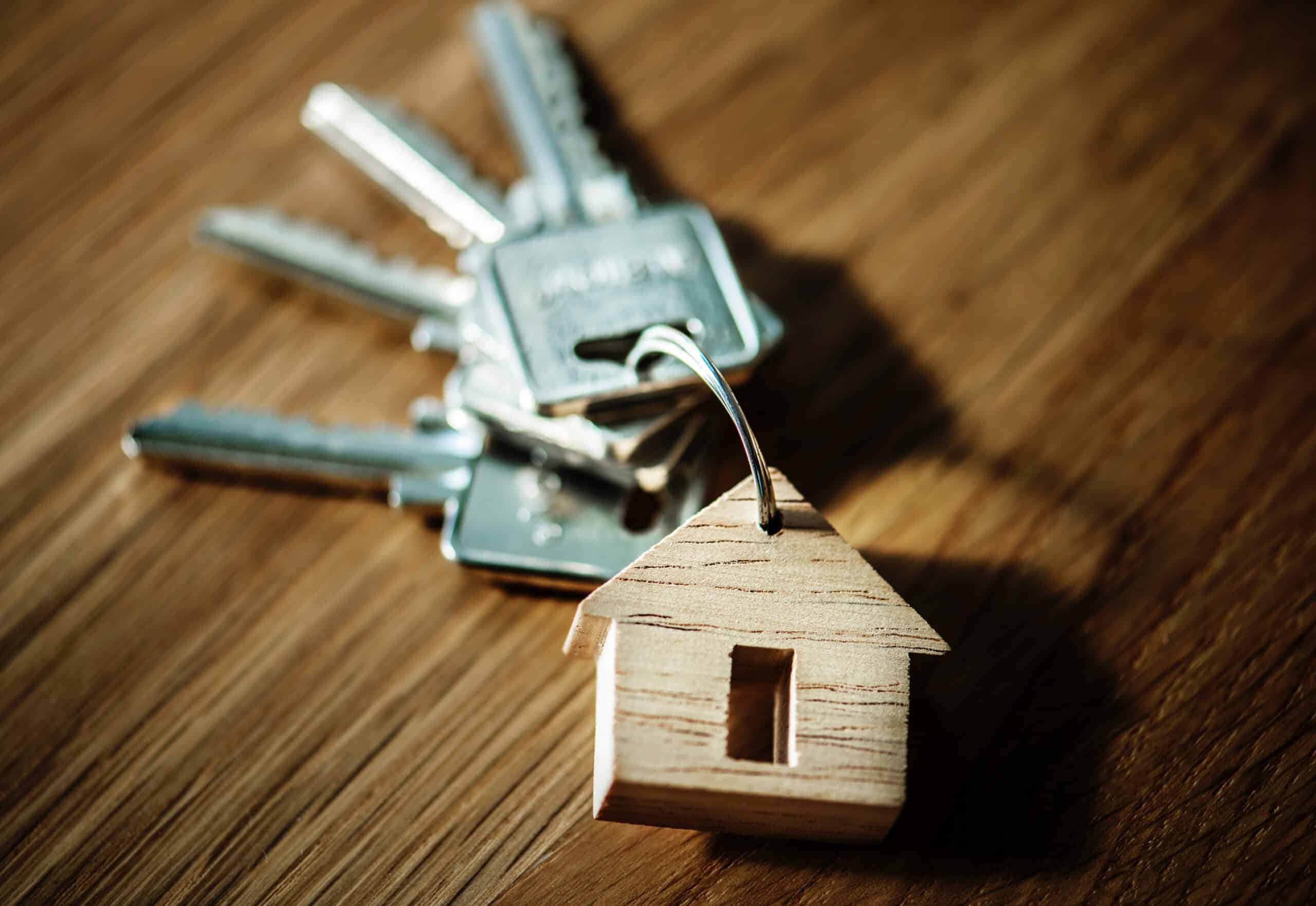 Un trousseau de clé avec un porte clef en forme de maison