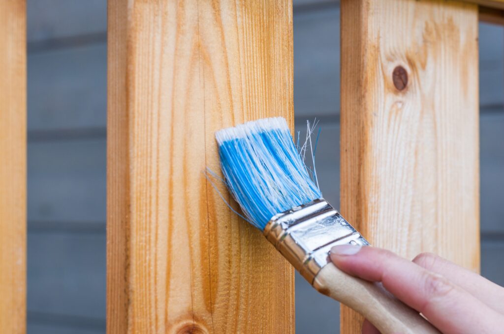 Des travaux de peintruee sur bois avec un pinceau